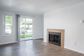 an empty living room with a fireplace and a door to the street